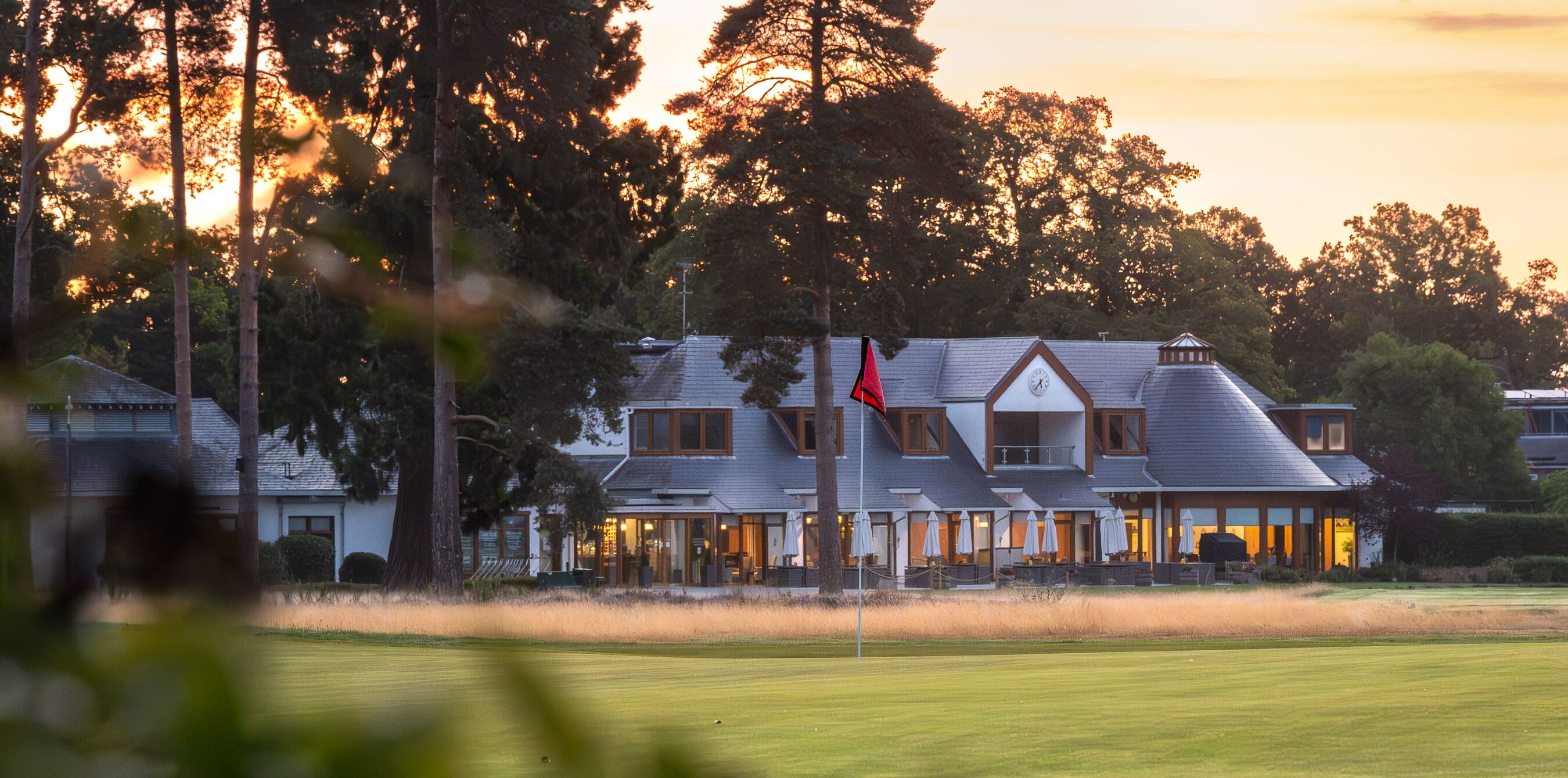 The clubhouse at North Hants Golf Club at dawn, seen across the course