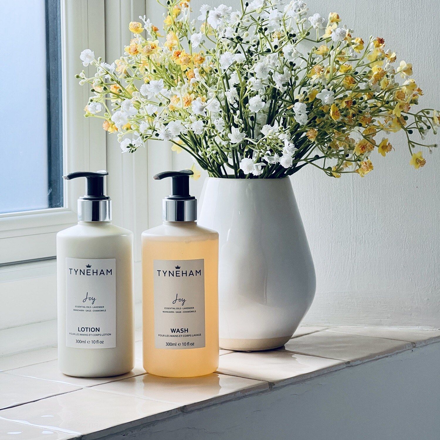 Premium hand wash and lotion in pump bottles on a washroom windowsill