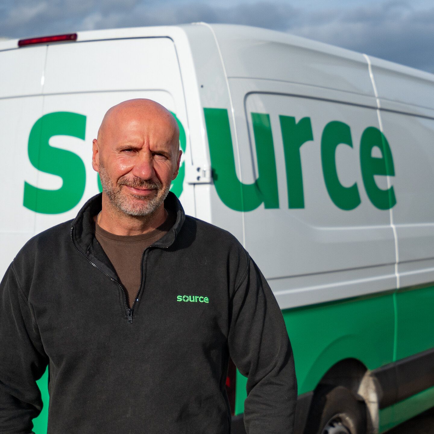 Adam from the Source team in front of a Source electric delivery van